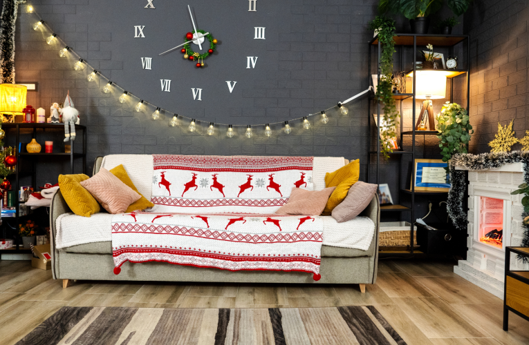 A cozy living room adorned with a festive Christmas-themed tapestry draped over the sofa.